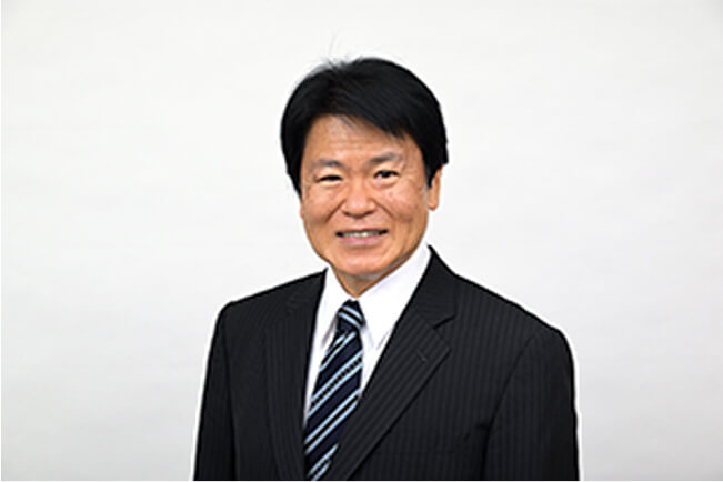 スーツ姿で笑顔の津田博夫の写真